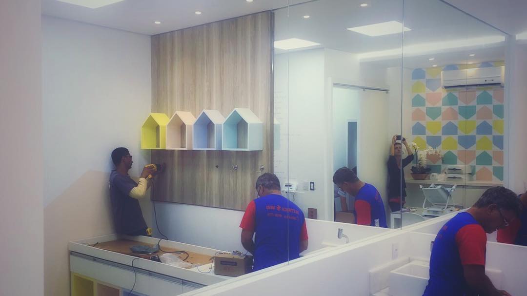 Consultório pediátrico em fase final de obra, com nichos em forma de casinha e parede de losangos coloridos